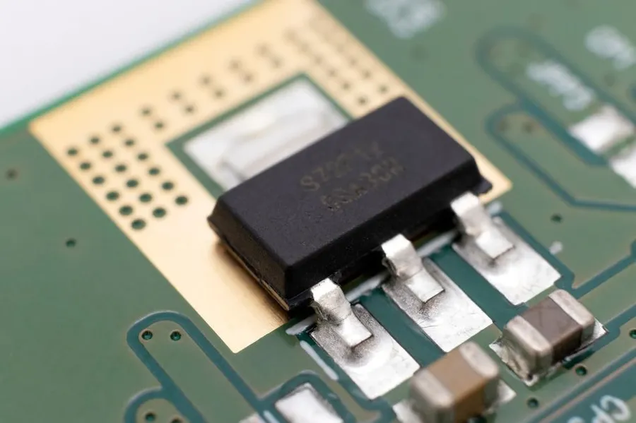 An electronic circuit board with various SMD transistors.